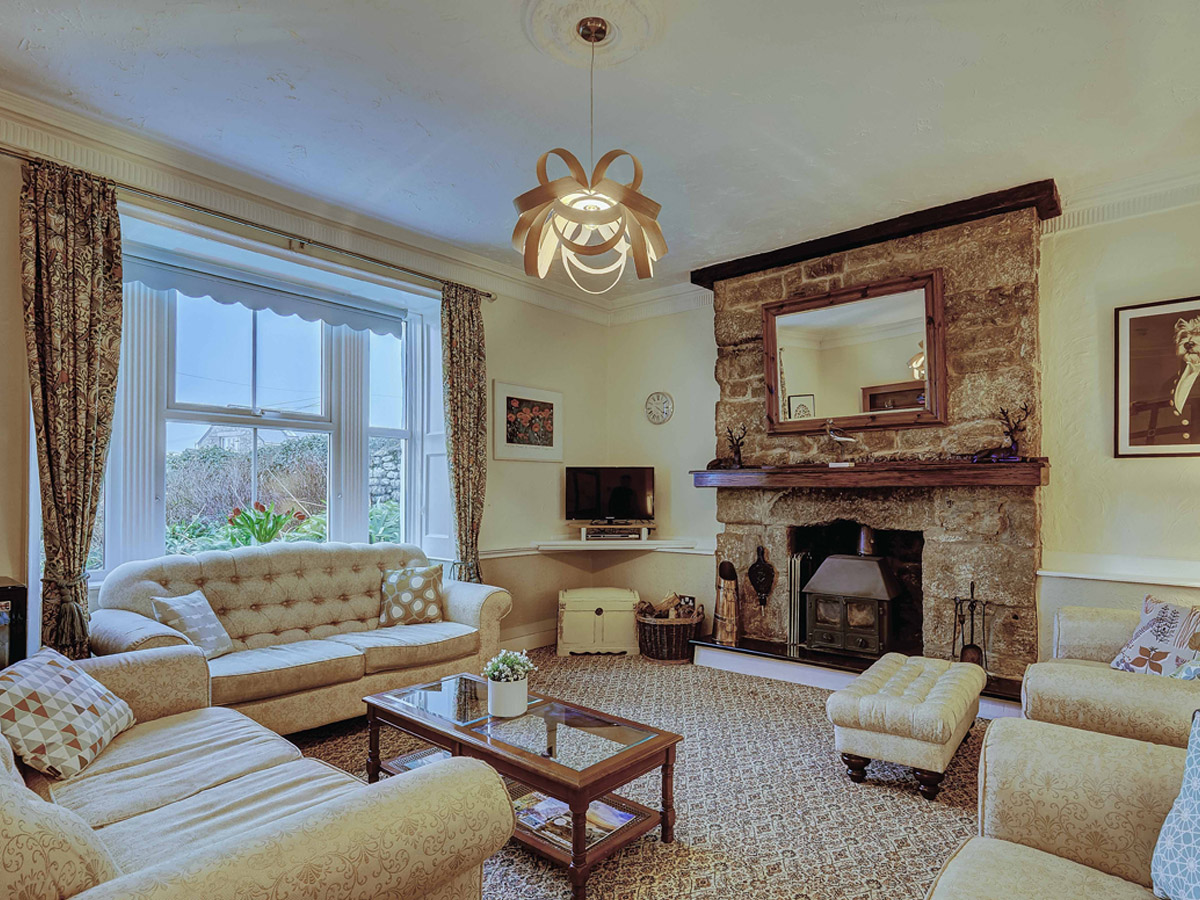 Guest lounge with granite fireplace at Bosavern House
