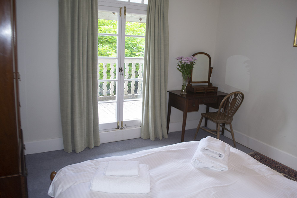 Bedroom One with double bed (5 ft) and double doors to balcony with sea view