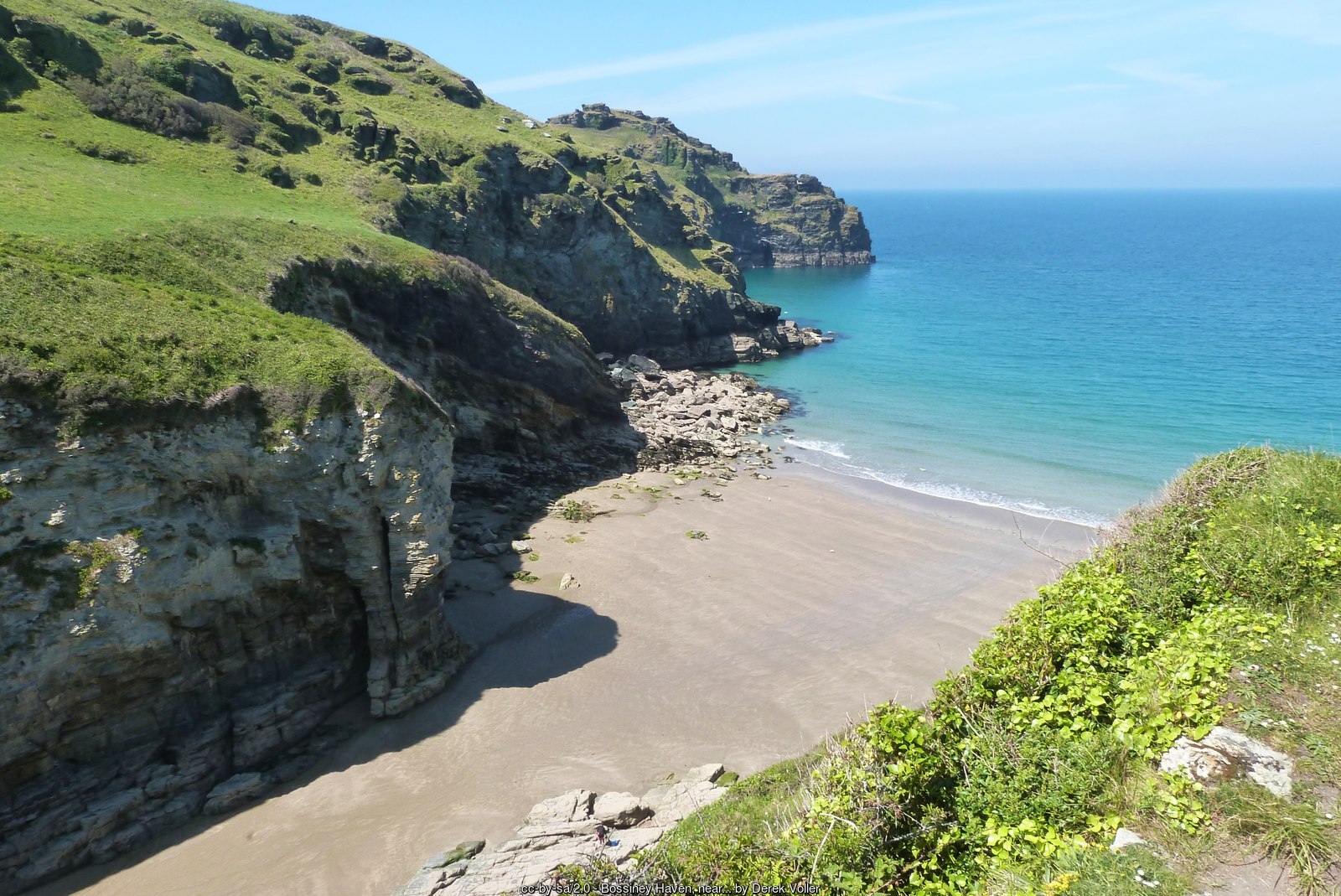 Bossiney Haven, a small sandy cove below green cliffs near Tintagel