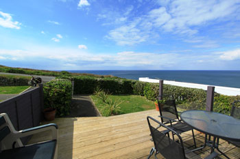 Decking with garden furniture and sea views at 1 Surfview