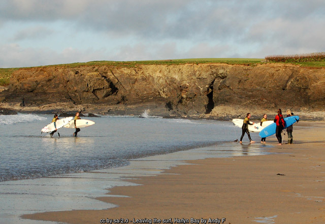 Surfers and a surf school on the sand at Harlyn Bay, Cornwall