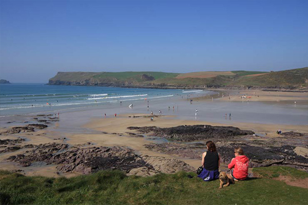 Watching the surfers at Polzeath Beach - Cornwall coastal walking holidays