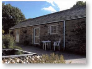 Stone cottage and patio with raised fishpond at Coldharbour Farm